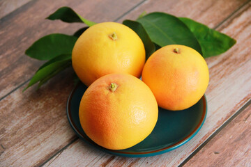 orange grapefruit fruit on green leaves