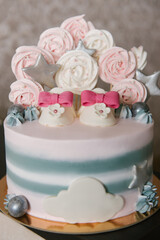 A beautiful cake made of natural ingredients with children's shoes in pink and gray colors for a girl's birthday or christening