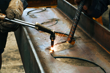 Craftsman cutting steel with sparks fly from gas cutting machine.