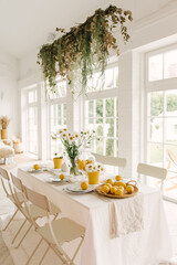 Beautifully served spring summer white table with lots of lemons and chamomile.