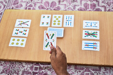 young boy playing truco game on wooden plank, Spanish playing cards (Baraja española) , Gambling,...