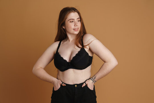 Smiling young plus size woman wearing bra posing