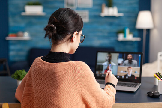 Young woman using laptop computer talking with collegue about school communication project during university videocall meeting. Student on remote e-learning education during coronavirus quarantine