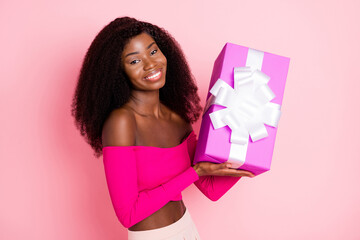 Photo of charming lady hold giftbox look camera toothy beaming smile wear cropped top isolated pink background