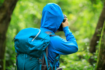 Woman photographer taking photo  in spring forest