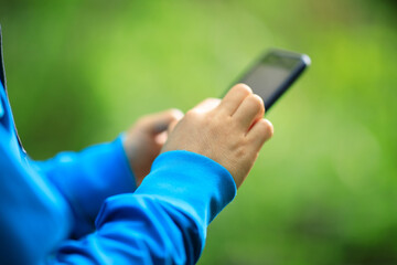 Woman hiker using smartphone  in spring forest