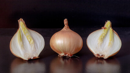 Whole bulb and bulb cut in half on a black background