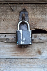 vintage lock on a rusty loop on a wooden background, copy space, concept of authentic objects