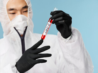 Asian male man protective clothing black gloves blood test examination blue background