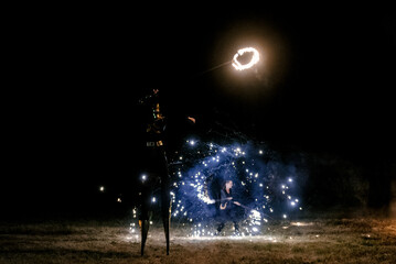Fire show. Fakir juggles with fire Poi. Night performance. Illusion of a suspended object