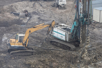 Wheel loader Excavator with backhoe unloading sand at eathmoving works in construction site.