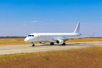 Big passenger airplane drives along the runway in airport