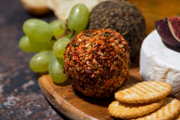 closeup of cheese, crackers and fruits, delicious snacks on wooden board