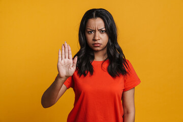 Displeased black woman showing stop gesture at camera