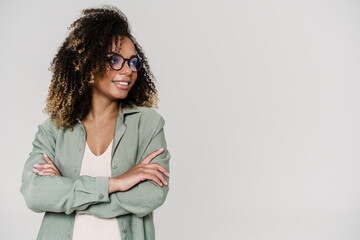 A happy woman with crossing arms in front of herself looking to the side in the studio