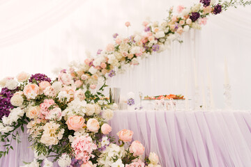 Luxury wedding dinner in a large beautiful tent, beautiful decor for the wedding of the white hall decorated with flowers