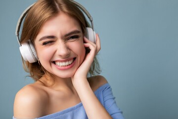 Closeup portrait of attractive happy smiling young blonde woman wearing blue crop top isolated on...