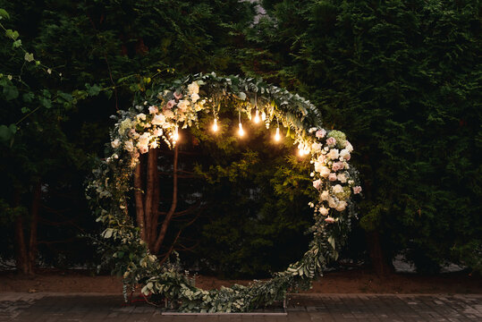 Beautiful wedding arch with retro lights decorated with night flowers, newlyweds ' night reception area