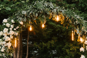 Beautiful wedding arch with retro lights decorated with night flowers, newlyweds ' night reception area