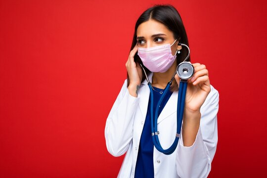 Photo of professional confident young european brunnet woman doctor in medical mask and white coat, stethoscope over neck, ready help patient, fight disease