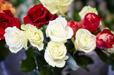 Blurred image of bouquet of fresh roses in flower shop. Spring floral rose bunch