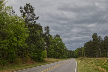Fototapeta premium Long country road on a storm cloud day mailbox
