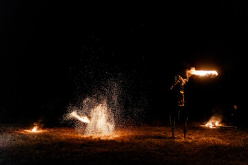 Obraz premium Fire show. Fakir juggles with fire Poi. Night performance. Illusion of a suspended object