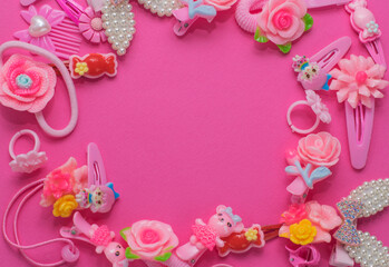 Frame of cute pink girls hair accessories on a pink background. Copy space, place for text