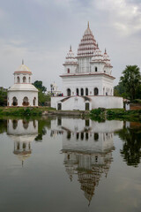 Fototapeta premium View of ancient white Bhubaneshwar Shiva temple with reflection in Shiv Sagar pond, Puthia, Rajshahi district, Bangladesh