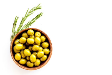 Wooden bowl of pickled green olives, top view