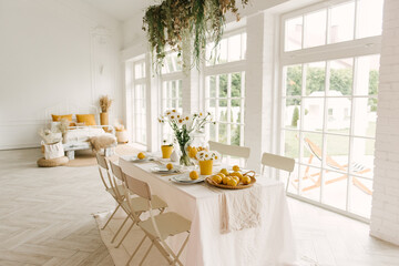 Beautifully served spring summer white table with lots of lemons and chamomile.