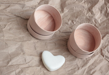 Eco-friendly disposable packaging,   plastic free lifestyle. On a paper background there are two empty round birch bark boxes,  dry shampoo in the form of a white heart. 