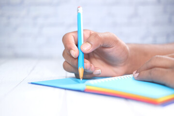 Close up of man hand writing on notepad.