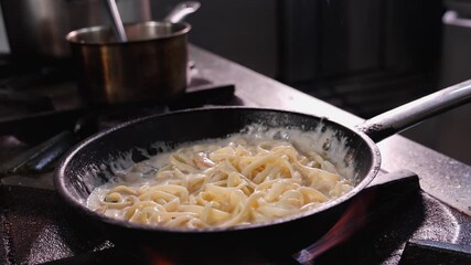 Chef preparing prawn or shrimps with cooking cream and spaghetti - tossing the pan to mix the ingredients, close up - Powered by Adobe