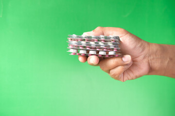 Close up of hand holding blister packs .