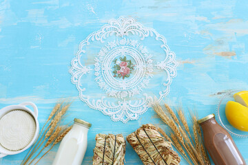 Top view photo of dairy products over blue wooden background. Symbols of jewish holiday - Shavuot