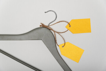 Grey coat hanger with yellow paper labels on white background. Blank label , mockup template....