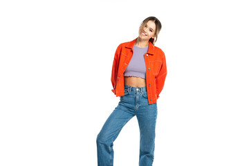 Fototapeta premium happy young woman in jeans, crop top and orange shirt isolated on white