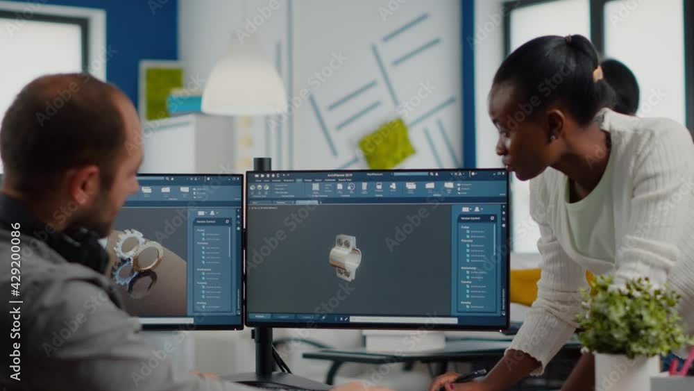 Poster multiethnic team sharing ideas about industrial project using dual displays setup with 3d gears and 