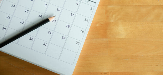 Fototapeta premium close up top view on white calendar 2026 month schedule to make appointment meeting or manage timetable each day lay on wood table background for planning work and life concept 