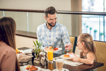 Young father having a breakfast with his daughter