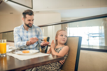 A cute girl having breakfast with her dad