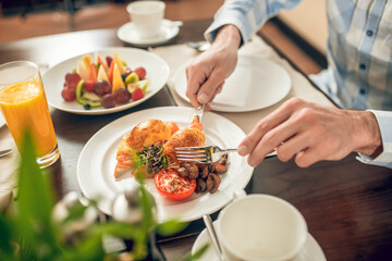 Close up picture of mans hands holding a fork and a knife