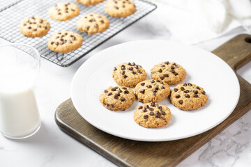 Delicious Whole Wheat Chocolate Chip Cookies set on white cafe table.