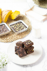 flourless pumpkin chocolate brownies set on white cafe table.