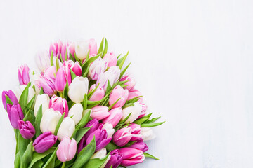 Colorful tulips bouquet on a light background, selective focus. Mothers Day, birthday celebration concept.
