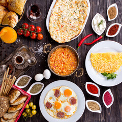 Assorted Middle Eastern and arabic dishes on a dark rustic background. Hummus, tabbouleh, pita, meat kebab, falafel, baklava. Halal food. Top view. Turkish foods, Turkish pizza, Turkish breakfast