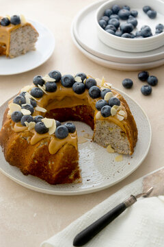 Bundt cake with peanut butter glaze. Healthy sugar gluten free cake with chia seeds decorated with blueberries and almond flakes.