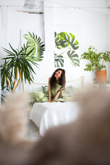 Smily nice woman is sitting on a bed 