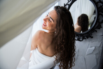 Smiling nice woman next to the mirror enjoying the bath time 